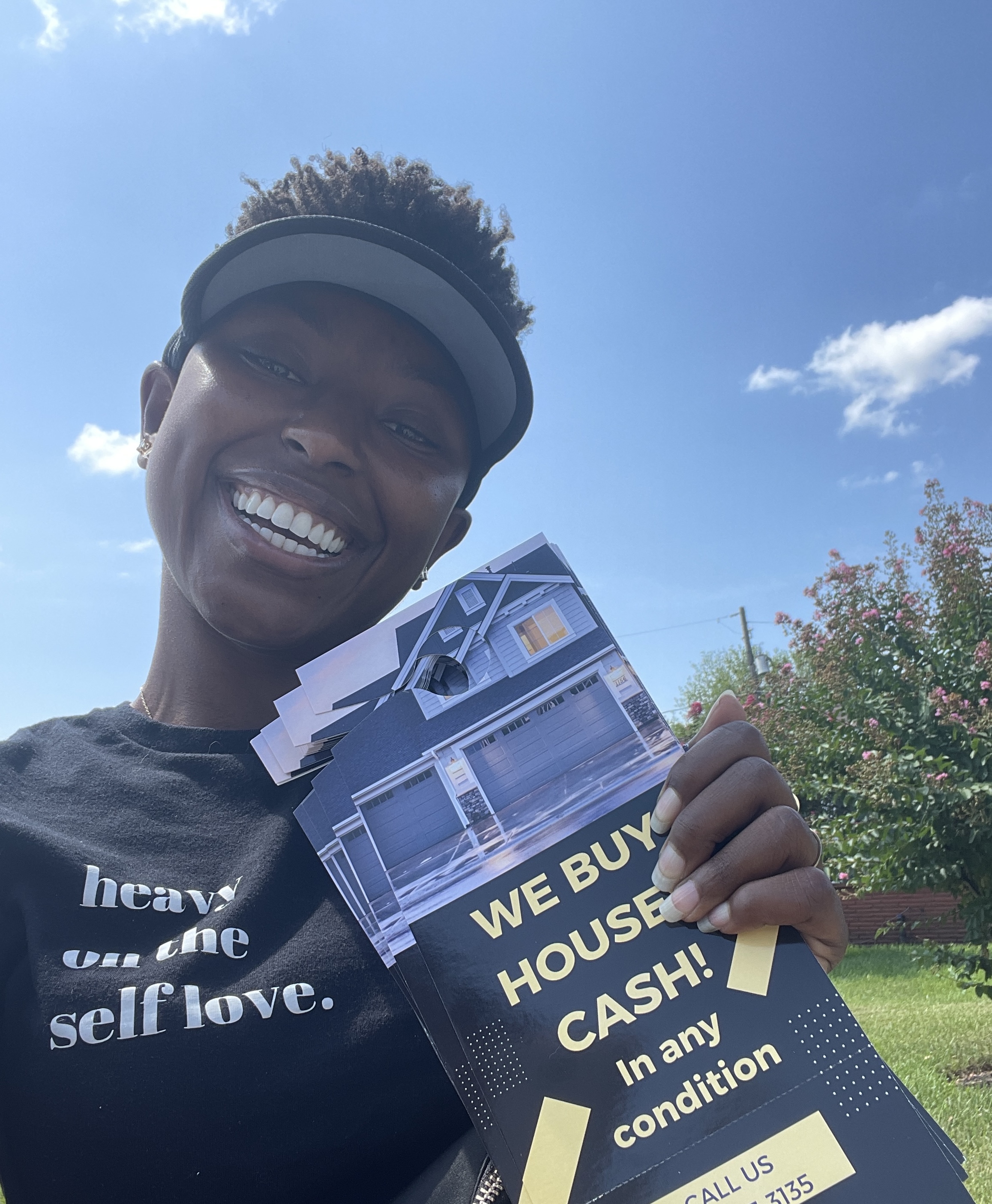 Ashlee holding a we buy houses sign